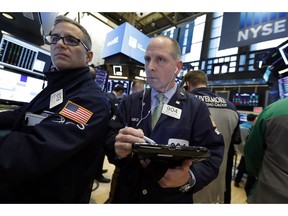FILE- In this March 7, 2019, file photo specialist Anthony Rinaldi, left, and trader Michael Urkonis work on the floor of the New York Stock Exchange. The U.S. stock market opens at 9:30 a.m. EDT on Friday, March 29.