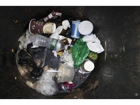 A plastic water bottle and plastic bags are seen discarded with other garbage in a corner trash can in the East Village neighborhood of Manhattan, Wednesday, March 27, 2019 in New York. Two New York lawmakers say Wednesday that they're optimistic that a ban on single-use plastic shopping bags could be included in the spending plan that's due Sunday.