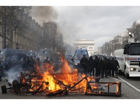 A barricade burns on the Champs Elysees avenue Saturday, March 16, 2019 in Paris. French yellow vest protesters clashed Saturday with riot police near the Arc de Triomphe as they kicked off their 18th straight weekend of demonstrations against President Emmanuel Macron.