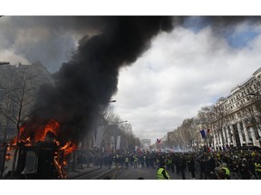 A news stand burns during a yellow vests demonstration on the Champs Elysees avenue Saturday, March 16, 2019 in Paris. French yellow vest protesters clashed Saturday with riot police near the Arc de Triomphe as they kicked off their 18th straight weekend of demonstrations against President Emmanuel Macron.