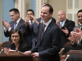 Quebec Finance Minister Eric Girard is applauded by the government as he stands to present his budget Thursday.