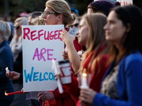 Supporters hold candles and signs during a Refugees Welcome rally held at the Alberta Legislature in Edmonton, Alta., on Tuesday September 8, 2015.
