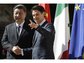 Chinese President Xi Jinping, left, and Italian Premier Giuseppe Conte shake their hands as they meet at Rome's Villa Madama, Saturday, March 23, 2019.