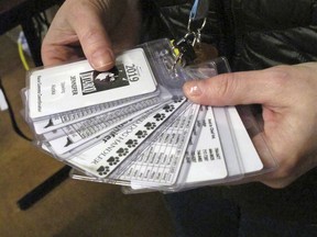 In this Tuesday, March 5, 2019 photo, a collection of tags are shown that volunteer Jennifer Dowling keeps with her inside a hotel in Anchorage, Alaska, where she is helping to track the 1,000-mile Iditarod Trail Sled Dog Race. As of Friday, 51 mushers are traveling long stretches between remote village checkpoints with no other company but the dogs pulling their sleds. Their progress is monitored from several hotel rooms whose 24/7 occupants are the Iditarod's electronic eyes and ears.