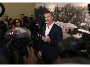 In this photo taken Tuesday, March 26, 2019, Gov. Gavin Newsom talks with reporters in Sacramento, Calif. Newsom, on Thursday, March 28, says PG&E plans to remake its board of directors with hedge fund financiers and people who have little experience in utility operations and safety. Putting hedge fund managers in charge of the company, said Newsom, will send a message the utility prioritizes profits over providing safe and reliable energy service. The utility did not immediately comment.