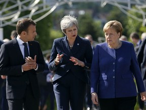 FILE - In this Thursday, May 17, 2018 file photo German Chancellor Angela Merkel, right, speaks with French President Emmanuel Macron, left, and British Prime Minister Theresa May after meeting at a hotel on the sidelines of the EU-Western Balkans summit in Sofia, Bulgaria.
