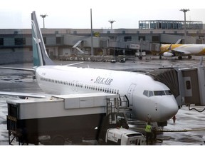 FILE - In this Oct. 4, 2017, file photo, SilkAir's new Boeing 737 Max 8 aircraft is seen through a viewing gallery window parked on the tarmac of Singapore's Changi International Airport. China's civilian aviation authority has ordered all Chinese airlines to temporarily ground their Boeing 737 Max 8 planes after one of the aircraft crashed in Ethiopia. The Civil Aviation Administration of China said the order was issued at 9 a.m. Beijing time Monday, March 11, 2019 and would last nine hours.