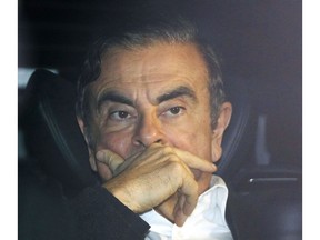 Former Nissan chairman Carlos Ghosn rides in a car from a building Wednesday, March 6, 2019, in Tokyo, after posting 1 billion yen ($8.9 million) in bail once an appeal by prosecutors against his release was rejected. Ghosn, the star auto executive credited with rescuing both Renault and Nissan, left a drab Tokyo detention center Wednesday after more than three months in custody, his identity obscured by a surgical mask, hat and construction worker's outfit.