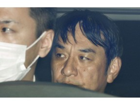 In this March 14, 2019, photo, Japanese musician Pierre Taki in a police car is sent to a prosecutor's office in Tokyo. Japanese entertainment company Sega has cancelled shipments of its video game "Judgment," also known as "Judge Eyes," after Taki was arrested on drug charges.