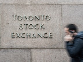 A pedestrian walks past the Toronto Stock Exchange sign in Toronto.