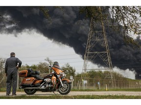 Bruce Bechtel, 64, stands next to his 2008 Harley-Davidson Ultra as he watches the plume of smoke caused by the petrochemical fire at the Intercontinental Terminals Company during his lunch break Monday, March 18, 2019, in Deer Park, Texas. The large fire at a Houston-area petrochemicals terminal will likely burn for another two days, authorities said Monday, noting that air quality around the facility was testing within normal guidelines.