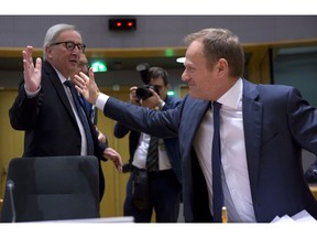 European Commission President Jean-Claude Juncker, left, greets European Council President Donald Tusk during a tripartite social summit at the Europa building in Brussels, Wednesday, March 20, 2019. European Union officials received a letter from British Prime Minister Theresa May requesting a Brexit extension and they hope to have more clarity about her intentions by Thursday.