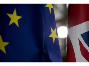 Light shines between the EU flag, left, and the Union Flag, right, prior to an EU summit at the Europa building in Brussels, Wednesday, March 20, 2019. European Union officials received a letter from British Prime Minister Theresa May requesting a Brexit extension and they hope to have more clarity about her intentions by Thursday.