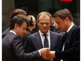 European Council President Donald Tusk, center, speaks with Italian Prime Minister Giuseppe Conte, left, and Luxembourg's Prime Minister Xavier Bettel during a round table meeting at an EU summit in Brussels, Thursday, March 21, 2019. British Prime Minister Theresa May is trying to persuade European Union leaders to delay Brexit by up to three months, just eight days before Britain is scheduled to leave the bloc.