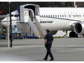 A worker walks next to a Boeing 737 MAX 8 airplane parked at Boeing Field, Thursday, March 14, 2019, in Seattle. The fatal crash Sunday of a 737 MAX 8 operated by Ethiopian Airlines was the second fatal flight for a Boeing 737 Max 8 in less than six months, and more than 40 countries, including the U.S., have now grounded the planes or refused to let them into their airspace.