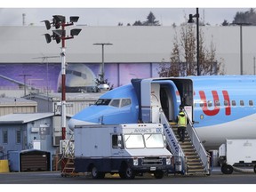 A worker walks up steps to the right of an avionics truck parked next to a Boeing 737 MAX 8 airplane being built for TUI Group at Boeing Co.'s Renton Assembly Plant Wednesday, March 13, 2019, in Renton, Wash. President Donald Trump says the U.S. is issuing an emergency order grounding all Boeing 737 Max 8 and Max 9 aircraft in the wake of a crash of an Ethiopian Airliner.