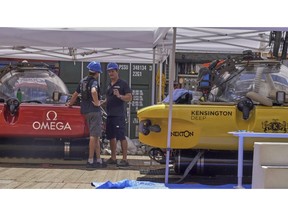 Submersible pilots from the UK-led Nekton Mission converse after one of their craft was forced to conduct an emergency ascent from 250 meters beneath the surface of the Indian ocean off the Seychelles, Tuesday March 19, 2019. A British scientist and her American pilot were inside the submersible when it filled with smoke. Both are now safe onboard the mother ship where an electrical fire aboard the sub is being investigated as the possible cause.