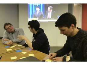 James Tabor, right, and other Tech For U.K. volunteers discuss ideas for anti-Brexit digital products in London, Thursday March 14, 2019. Members of Tech For U.K., a grassroots group of people working in Britain's tech industry, are using their tech skills to build online tools to help battle Brexit.