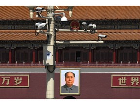 Surveillance cameras are mounted on a lamp post near the large portrait of Chinese leader Mao Zedong at the Tiananmen Gate in Beijing, Friday, March 15, 2019. Chinese Premier Li Keqiang on Friday denied Beijing tells its companies to spy abroad, refuting U.S. warnings that Chinese technology suppliers might be a security risk.