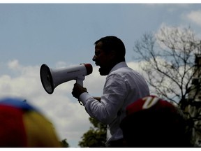 The leader of Venezuela's National Assembly Juan Guaido, who declared himself the country's interim president, uses a megaphone to speak to supporters during a rally against the government of President Nicolas Maduro, in Caracas, Venezuela, Saturday, March 9, 2019.
