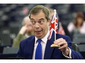 Former U.K. Independence Party (UKIP) leader and member of the European Parliament Nigel Farage holds a U.K. flag during a plenary session at the European Parliament in Strasbourg, eastern France, Wednesday, March 13, 2019. British lawmakers rejected May's Brexit deal in a 391-242 vote on Tuesday night. Parliament will vote Wednesday on whether to leave the EU without a deal.