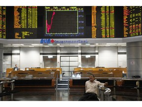 A visitor sits in front of private stock trading boards at a private stock market gallery in Kuala Lumpur, Malaysia, Friday, March 15, 2019. Shares were higher Friday in Asia after a day of lackluster trading on Wall Street.