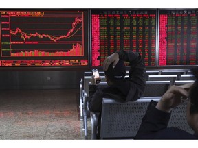 An investor plays a mobile chess game while watching stock prices at a brokerage in Beijing, China, Tuesday, March 19, 2019. Asian shares were mixed in muted trading Tuesday as investors awaited the U.S. Federal Reserve meeting later in the week.