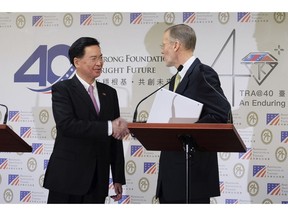 Taiwan Foreign Minister Joseph Wu, left, and American Institute in Taiwan (AIT) director William Brent Christensen shakes hands during a press conference in Taipei, Taiwan Tuesday, March 19, 2019. Taiwan and the U.S. will hold talks later this year as part of efforts to counter growing pressure from Beijing to force the island into political unification with mainland China.