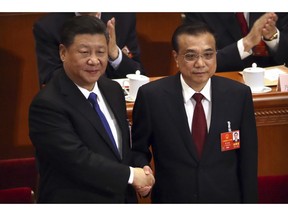 FILE- In this March 18, 2018, file photo, Chinese President Xi Jinping, left, shakes hands with Premier Li Keqiang after Li was re-elected as Premier during a plenary meeting of China's National People's Congress (NPC) at the Great Hall of the People in Beijing, Thousands of delegates from around China are gathering in Beijing for annual session of the country's rubber-stamp legislature and its advisory body, an event characterized more by the authoritarian ruling Communist Party leadership's desire to communicate its message than any actual discussion or passage of laws.