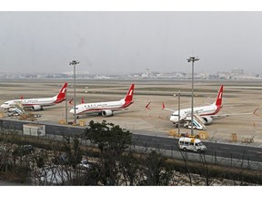 In this photo taken Monday, March 11, 2019, three Shanghai Airlines Boeing 737 Max 8 passenger planes are parked at the Hongqiao Airport in Shanghai, China. U.S. Aviation experts on Tuesday, March 12, 2019 joined the investigation into the crash of an Ethiopian Airlines jetliner that killed 157 people, as a growing number of airlines grounded the new Boeing plane involved in the crash. (Chinatopix via AP)