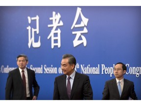 Chinese Foreign Minister Wang Yi, center, leaves after a press conference on the sidelines of the annual meeting of China's National People's Congress (NPC) in Beijing, Friday, March 8, 2019. The U.S.-North Korea summit in Vietnam last week was an "important step" toward denuclearization on the Korean peninsula, China's foreign minister said Friday.
