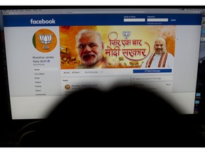 A woman checks the Facebook page of India's ruling Bharatiya Janata Party, in New Delhi, India, Tuesday, March 26, 2019.  Facebook says it is preparing for Indian elections by working to limit false stories, videos and photos on its platform. Indian politicians increasingly are using social media to run campaign advertisements, share political songs and interact with young voters. Polling in the general election is to take place in seven stages from April 11 to May 19.