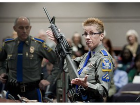 FILE - In this Jan. 28, 2013, file photo, firearms training unit Detective Barbara J. Mattson, of the Connecticut State Police, holds a Bushmaster AR-15 rifle, the same make and model used by Adam Lanza in the 2012 Sandy Hook School shooting, during a hearing at the Legislative Office Building in Hartford, Conn. A divided Connecticut Supreme Court ruled that gun maker Remington can be sued over how it marketed the Bushmaster rifle used in the massacre.  In court documents filed Friday, April 5, 2019, Remington notified the Connecticut Supreme Court of its plans to pursue an appeal with the Supreme Court of the United States.