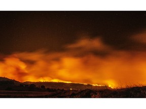 FILE - In this Nov. 8, 2018 file photo, the Camp Fire burns as it lights up the sky under bright stars near Pentz Rd., in Paradise, Calif. More than 2.7 million Californians live in areas that are at very high risk for wildfires. The more information we can share about where and how we're falling short, the quicker we can come together on potential solutions.