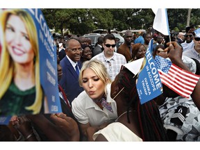White House senior adviser Ivanka Trump is greeted by kisses as she is welcomed by local people holding U.S. flags and small flags that say "Welcome In Adzope Ivanka Trump We Love U," in Adzope, Ivory Coast, Wednesday April 17, 2019, where she will visit Cayat, a cocoa and coffee cooperative. Trump is in Ivory Coast to promote a White House global economic program for women.