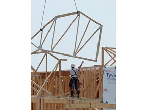 Construction workers build new homes in a development in Ottawa on Monday, July 6, 2015. Canada Mortgage and Housing Corp. says the annual pace of housing starts picked up in March.