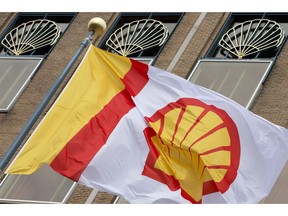 In this Monday, April 7, 2014 file photo, a flag bearing the company logo of Royal Dutch Shell, flies outside the head office in The Hague, Netherlands. Global oil giant Royal Dutch Shell is urging Canada's largest oil and gas organization to get off the fence and support both the Paris climate accord and the pricing of carbon to encourage greenhouse gas emission reduction.