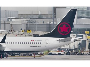 An Air Canada Boeing 737 Max 8 aircraft is shown next to a gate at Trudeau Airport in Montreal on March 13, 2019. Air Canada says it is removing its grounded Boeing 737 Max jets from service until at least Aug. 1 in order to provide more certainty for passengers with summer travel plans.