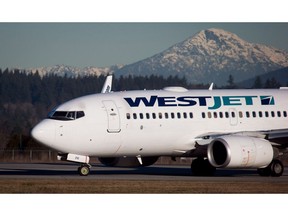 A pilot taxis a Westjet Boeing 737-700 plane to a gate after arriving at Vancouver International Airport in Richmond, B.C., on Monday February 3, 2014. WestJet Airlines Ltd. and its 510 regional pilots have reached a tentative bargaining agreement.