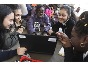 FILE - In this file photo taken Feb. 21, 2019, seventh grade students from Grace Academy in Hartford, Conn., work together on a robot using plans on a computer at the Connecticut Science Center in Hartford. Though less likely to study in a formal technology or engineering course, America's girls are showing more mastery of those subjects than their boy classmates, according to newly released national education data made public Tuesday, April 30, 2019.