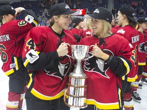 algary Inferno's Zoe Hickel (left) and Tori Hickel celebrate with the trophy after beating Les Canadiennes de Montreal 5-2 to win the 2019 Clarkson Cup game in Toronto, on Sunday, March 24 , 2019.