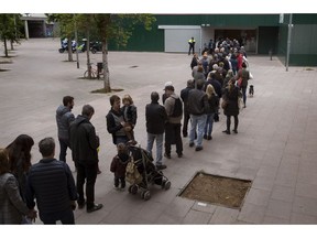 People line up outside a polling station to cast their vote for the general election in Barcelona, Spain, Sunday, April 28, 2019. Galvanized by the Catalan crisis, Spain's far right is set to enter Parliament for the first time in decades while the Socialist government tries to cling on to power in Spain's third election in four years.