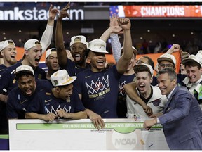 Virginia head coach Tony Bennett celebrates with his team after defeating Texas Tech 85-77 in the overtime in the championship of the Final Four NCAA college basketball tournament, Monday, April 8, 2019, in Minneapolis.