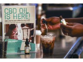 FILE - In this Jan. 4, 2018, file photo, a worker adds cannabidiol (CBD) to a drink at a coffee shop in Fort Lauderdale, Fla. Mainstream retailers are leaping into the world of products like skin creams and oils that tout such benefits as reducing anxiety and helping you sleep. The key ingredient is CBD, or cannabidiol, a compound derived from hemp and marijuana that doesn't cause a high.