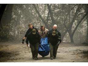 FILE - In this Saturday, Nov. 10, 2018 file photo, sheriff's deputies recover the remains of a victim of the Camp Fire on in Paradise, Calif. More than 2.7 million Californians live in areas that are at very high risk for wildfires. One in 12 homes in California are at high risk of burning in a wildfire. The more information we can share about where and how we're falling short, the quicker we can come together on potential solutions.