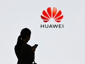 A staff member of Huawei uses her mobile phone at the Huawei Digital Transformation Showcase in Shenzhen, China.