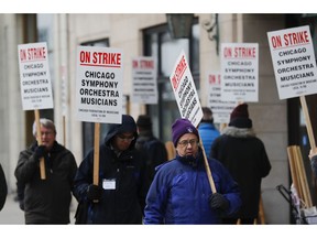 FILE - In this Monday, March 11, 2019 file photo, striking Chicago Symphony Orchestra musicians walk the picket line outside of Symphony Center in Chicago. On Saturday, April 27, 2019, negotiators for the Chicago Symphony Orchestra and musicians said they have reached an agreement to end the seven-week strike.