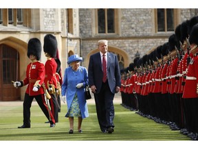 FILE - In this Friday, July 13, 2018 file photo, U.S. President Donald Trump and Britain's Queen Elizabeth inspects the Guard of Honour at Windsor Castle in Windsor, England. U.S. President Donald Trump will pay a state visit to Britain in June as a guest of Queen Elizabeth II, Buckingham Palace said Tuesday, April 23, 2019. The palace said Trump and his wife, Melania, had accepted an invitation from the queen for a visit that will take place June 3-5.