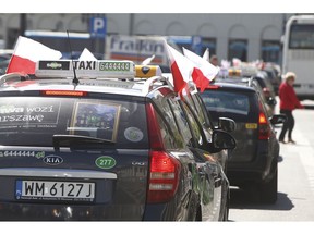 FILE - In this Monday, June 5, 2017 file photo, taxi drivers block traffic as they protest the growing number of unlicensed drivers offering transport services in Warsaw, Poland. Hundreds of taxi drivers drove at a crawl and walked in Poland's capital to protest a new law allowing and regulating ride-hailing services like Uber. The protesters who held up Warsaw traffic on Monday, April 8, 2019 said the law approved last week will put cabbies out of work by subjecting them to unfair competition from people who don't drive professionally. Infrastructure Minister Andrzej Adamczyk said the law requires ride-hailing services to pay taxes and observe the same rules as cab companies.
