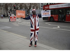 A pro-Brexit leave the European Union supporter holds up placards outside the Houses of Parliament in London, Wednesday, April 3, 2019. After failing repeatedly to win Parliament's backing for her Brexit blueprint, Britain's Prime Minister Theresa May dramatically changed gear Tuesday, saying she would seek to delay Brexit _ again _ and hold talks with the opposition to seek a compromise.